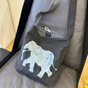Detail of vintage canvas crossbody bag with elephant print and plaid lining texture