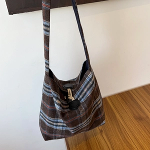Detail of vintage brown plaid wool shoulder bag with unique leather clasp and drawstring
