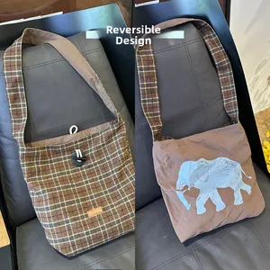 Reversible tote bag showing a brown tartan pattern and a solid blue elephant print