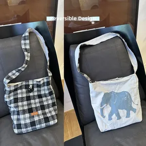 Reversible canvas tote bag featuring black plaid and blue elephant graphic patterns