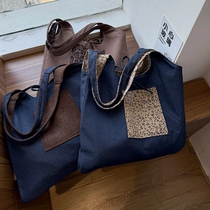 Detail of denim and fabric tote bags featuring leopard print straps and outer pockets
