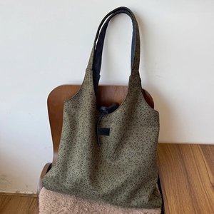 Detail of olive green leopard print tote bag with black drawstring and MODEST logo patch