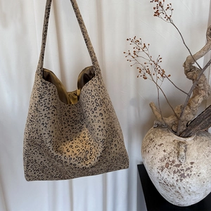 Detail of leopard print tote bag featuring a luxurious golden satin inner lining