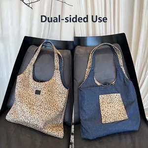 Detail of reversible tote bag showing leopard print canvas and dark blue denim sides