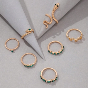 Lot de sept bagues serpent dorées serties de pierres vertes et de cristaux brillants