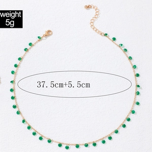 Detail of gold clavicle chain with green beads featuring weight 5g and 43cm length