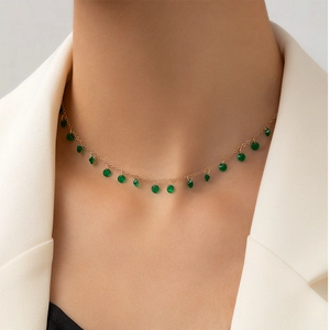 Detail of French vintage gold necklace with irregular green stone pendants on neck