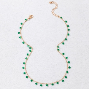 Detail of gold necklace with green beads, lobster clasp and adjustable chain