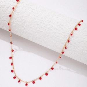 Macro shot of French retro red pendant necklace with golden faceted glass beads