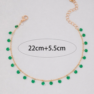 Detailed view of the 22cm gold chain with round green stone pendants and lobster clasp