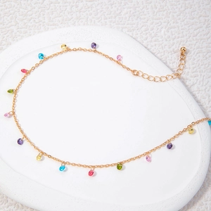Detailed view of gold clavicle chain with colorful crystal pendants and lobster clasp