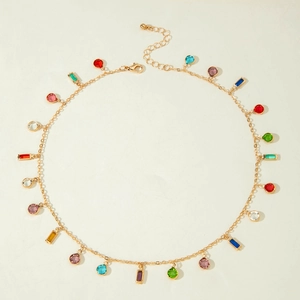 Detail of gold necklace featuring colorful round and rectangular crystal pendants