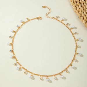 Detail of French vintage necklace with gold chain, white pearls and colorful crystals
