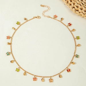 Close-up of gold chain necklace featuring colorful butterfly and teardrop charms