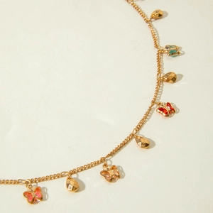 Detail of gold necklace chain with colorful enamel butterflies and faceted metal drops