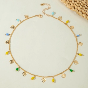 Detail of a gold choker with colorful waterdrop beads and spiral heart pendant charms