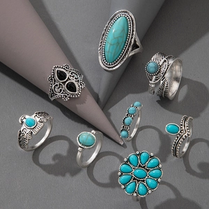 Detail view of 8-piece vintage silver rings with bohemian turquoise and feather carvings
