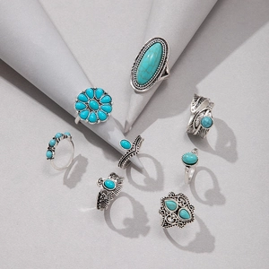 Detail of 8-piece vintage silver ring set with turquoise stones and floral patterns