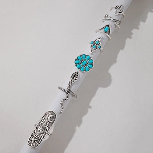 Close-up of vintage silver bohemian rings set featuring turquoise and floral designs