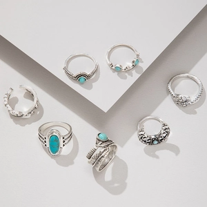 Detail of 7pcs vintage bohemian rings set with turquoise and feather motifs in silver finish