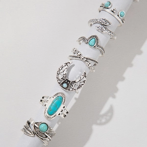 Detailed macro of 7-piece bohemian ring set featuring turquoise inlay and ethnic patterns