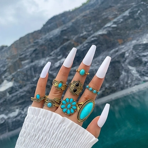 Detail of 8pcs vintage bohemian rings set with turquoise stones and floral patterns