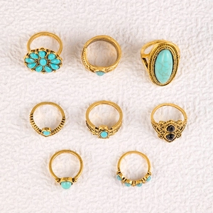 Detail of 8-piece vintage gold ring set with turquoise stones and floral patterns