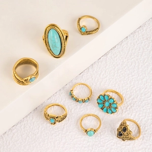 Detailed view of bohemian style turquoise rings with vintage gold floral and leaf motifs
