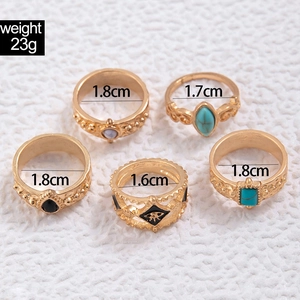 Close-up of vintage gold rings set with turquoise and etched bohemian patterns