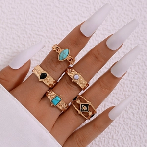 Detail of bohemian gold rings set with turquoise and evil eye symbols on hand