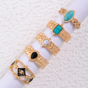 Detailed set of bohemian rings with turquoise, white marble, and black stones on a gold band