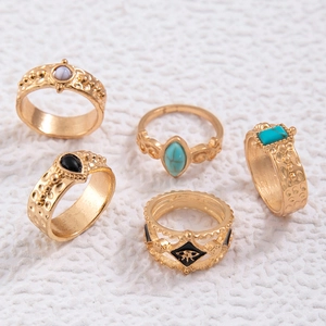 Detail of vintage bohemian gold rings set with turquoise and intricate carvings