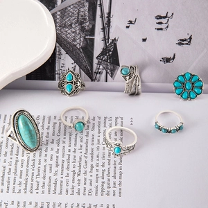 Close-up of bohemian 6-piece turquoise ring set with vintage silver floral and feather details