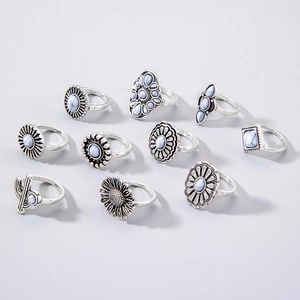 Detailed view of 10-piece vintage silver boho rings with white faux stone floral designs