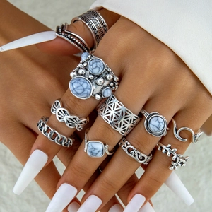 Detailed close-up of vintage silver rings with faux white turquoise on a hand