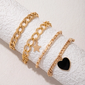 Golden geometric bracelet set with star charms and black heart pendants for stacking