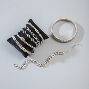 Detailed view of silver stackable bracelet set with link chains and knotted metal bangles