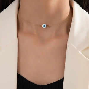 Minimalist gold choker necklace with blue evil eye pendant on model's neck