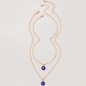 Detail of layered gold necklaces with blue evil eye pendants and adjustable lobster clasp