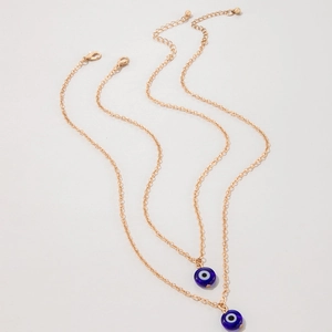 Close-up of two gold evil eye necklaces with blue charms and adjustable lobster clasp