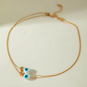 Double-layered gold necklace with blue evil eye beads and spherical metal charms