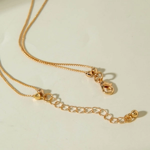 Detail of adjustable gold necklace with lobster clasp and box chain extension
