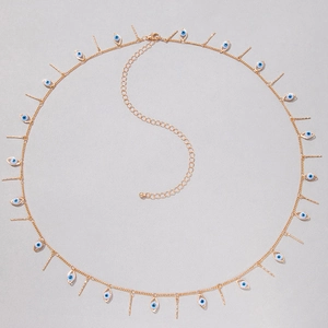 Detailed shot of golden evil eye pendants and vertical bar charms on a flat chain