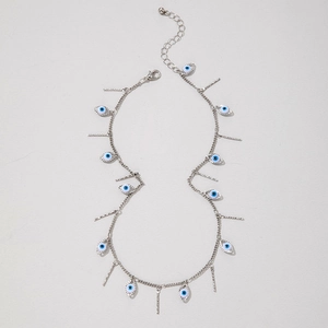 Detail of silver chain necklace with evil eye pendants and textured vertical bars