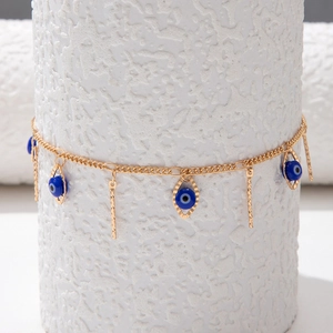 Detailed view of evil eye charms and vertical bar pendants on a gold link necklace