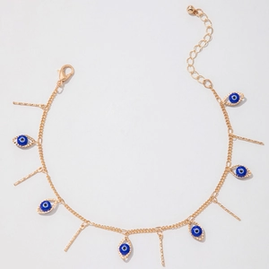 Macro detail of evil eye pendants and textured metal bars on gold plated anklet chain