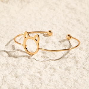 Vue latérale du bracelet doré ajouré oreilles de chat sur une surface en pierre