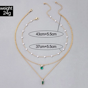 Détails du collier doré multicouche avec pendentifs émeraude et tour de cou en perles
