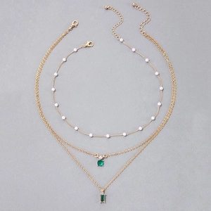 Détail du collier triple couche avec pendentif émeraude verte et chaîne perles