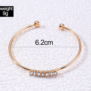 Detail view of gold floral pearl open bangle showing 9g weight and 6.2cm inner diameter